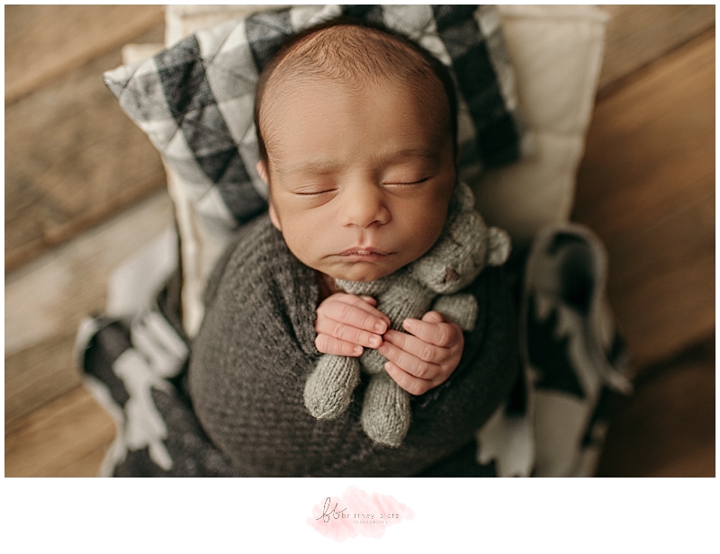 close up of baby boy snuggling teddy bear